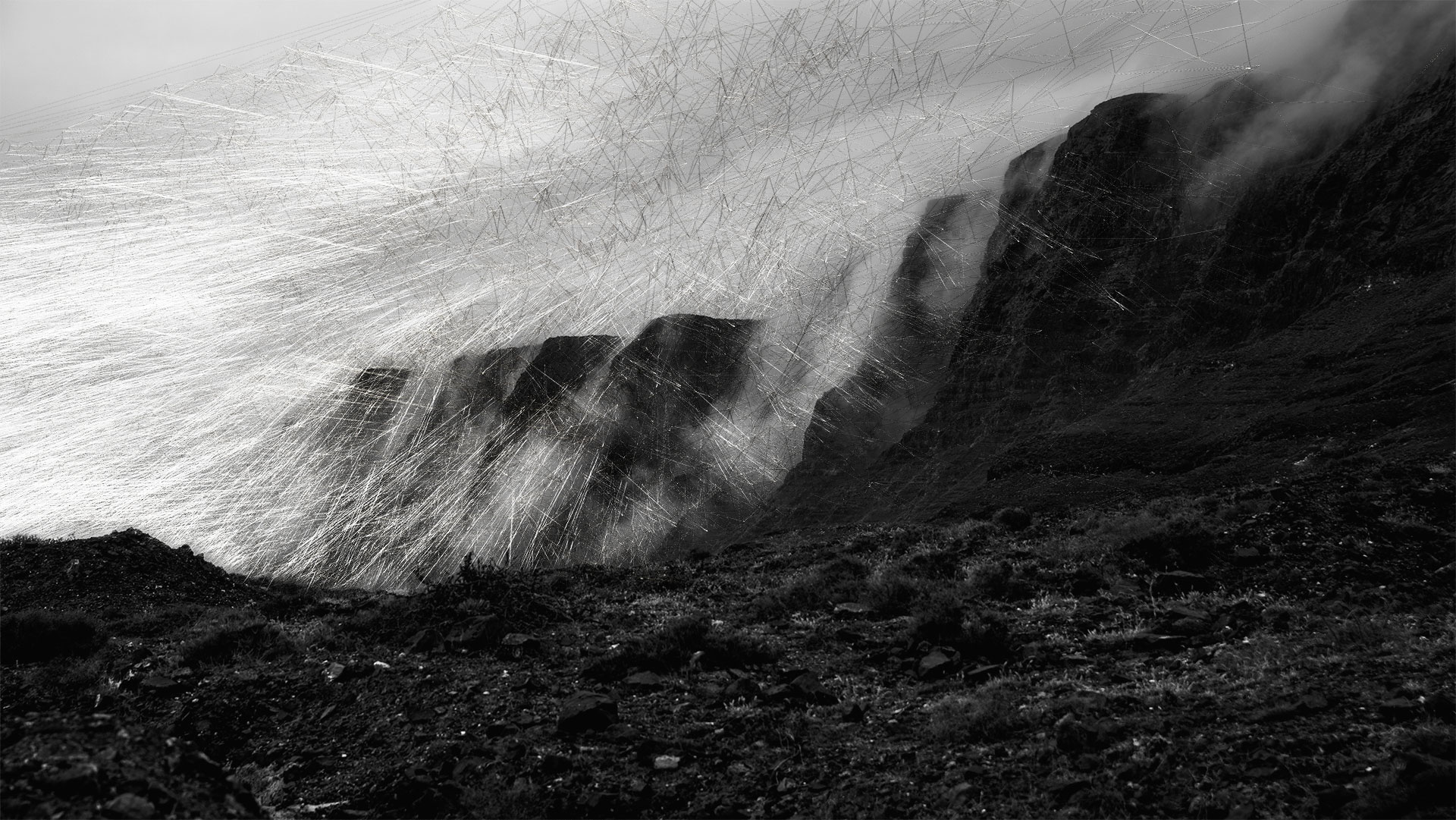 The series consists of three black and white images. The first motif shows a massive mountain ridge with clouds gliding down its slopes. In the foreground is a rock field in dark gray tones. The image area of the clouds is crisscrossed with aggressive rays. Overall, a gloomy image mood prevails.