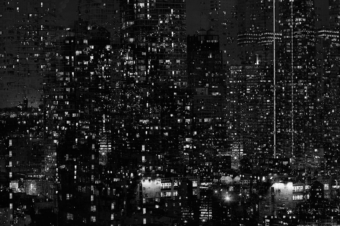 Opposite skyscrapers at night photographed from a hotel window. The many windows multiplied and illuminated by the superimposition create an unreal atmosphere.