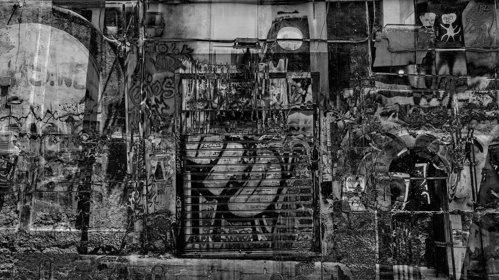 Eine mit Graffiti besprayte Wand mit bogenförmigen Elementen und ein Garagentor sind die Haupteleente dieser Einstellung.